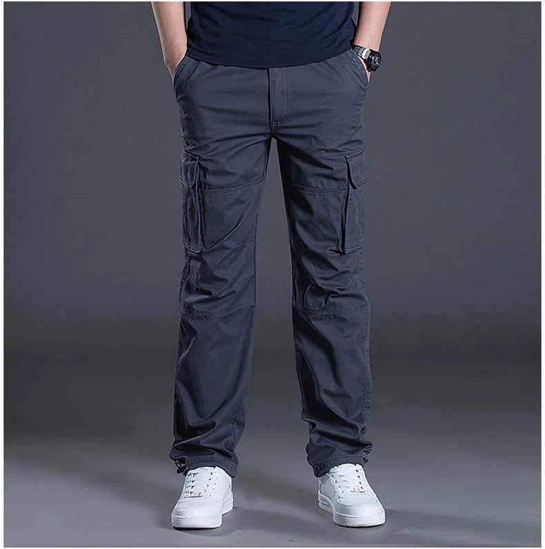 Person wearing dark gray cargo pants on a gray background