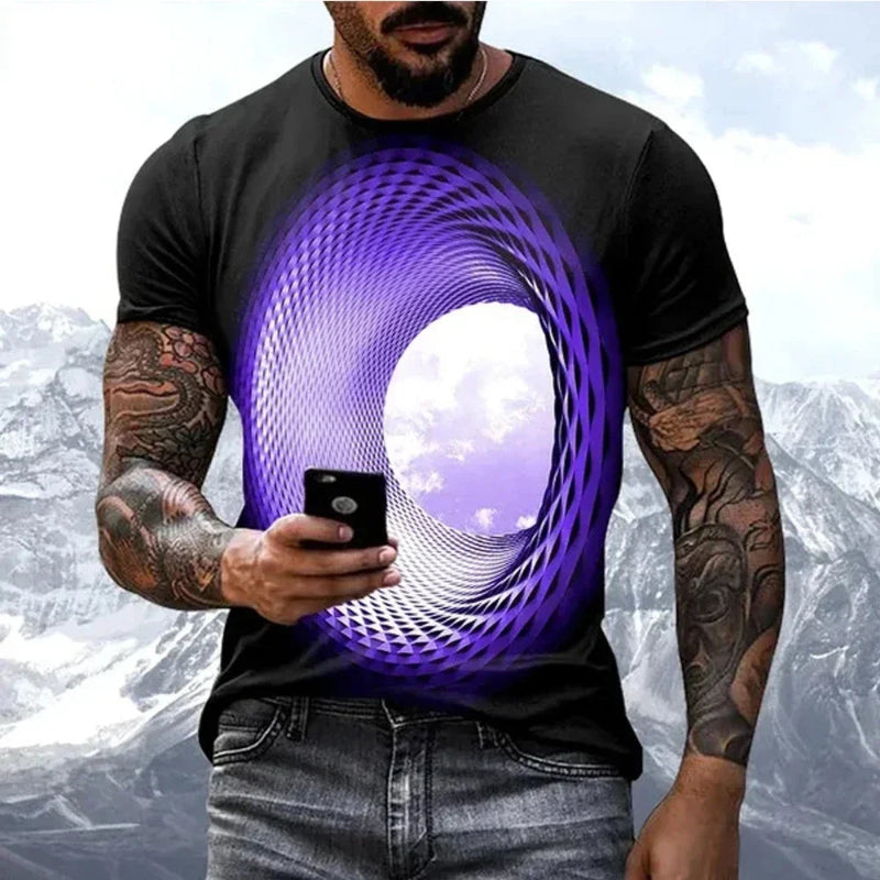 Person wearing a black t-shirt with a purple spiral design, holding a phone with a mountainous background.