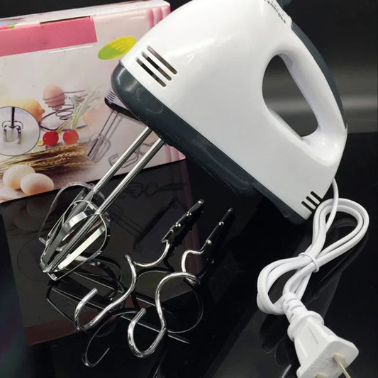 Hand mixer with attachments on a reflective surface