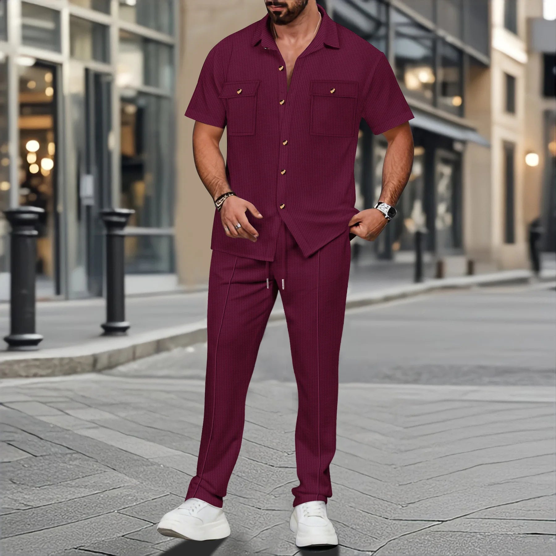 Man wearing a maroon outfit with white shoes on a city street.