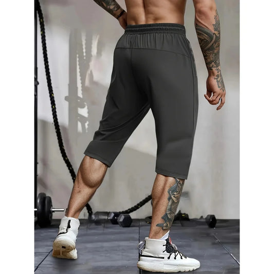 Person wearing dark gray athletic shorts in a gym setting