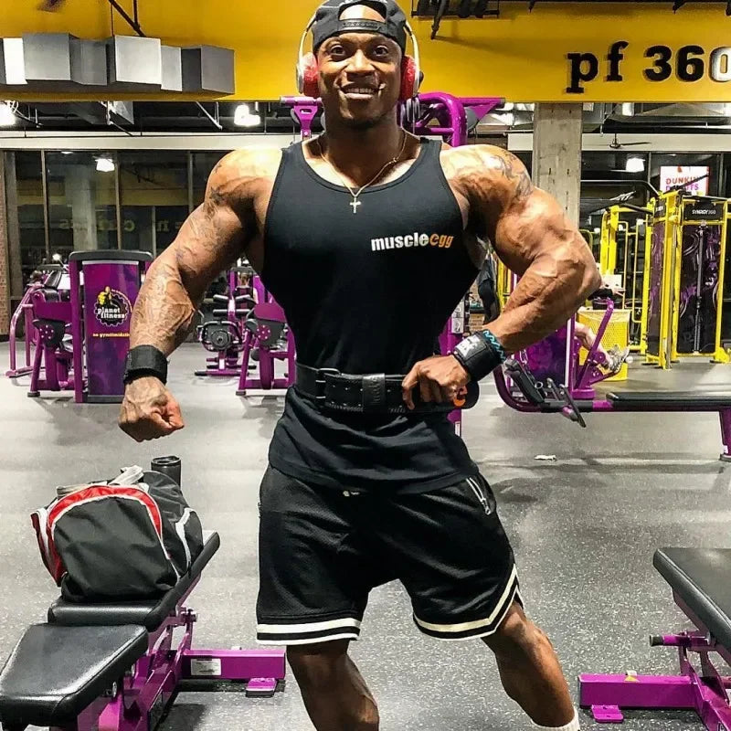 Muscular man in a gym wearing a 'muscle gym' tank top.