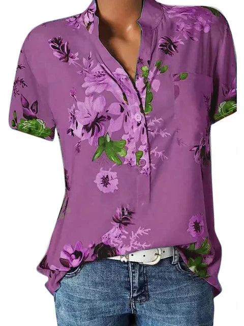 Purple floral blouse worn by a person on a white background