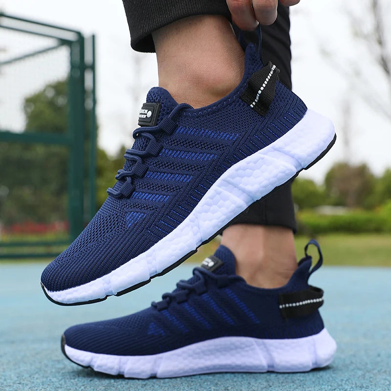 Navy blue running shoes with white soles worn by a person on a blurred outdoor background