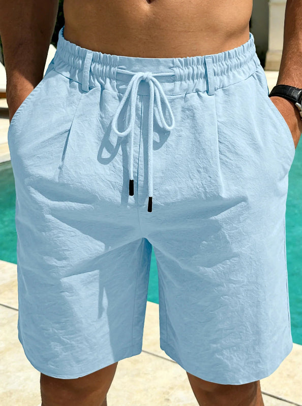 Light blue shorts with drawstring worn by a person by a pool.