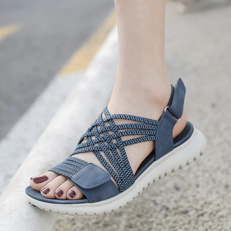 Blue sandals worn on a foot with a blurred background