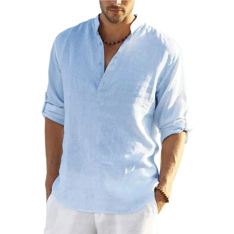 Man wearing a light blue linen shirt with rolled-up sleeves on a white background