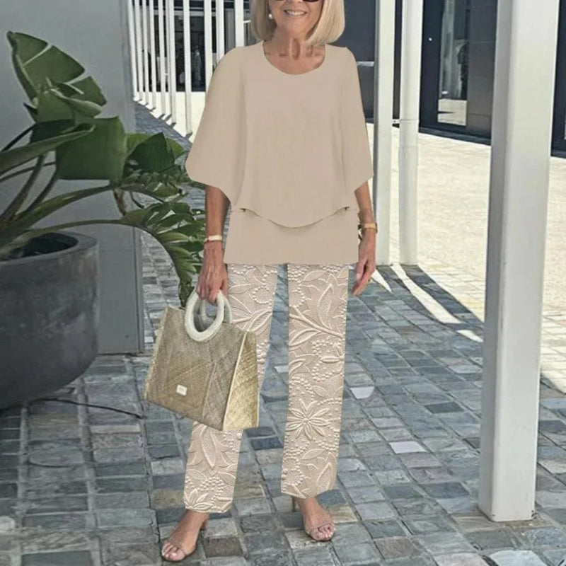 Woman in beige outfit holding a handbag on a patio