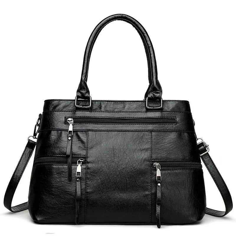 Black leather handbag with multiple pockets and zippers on a white background