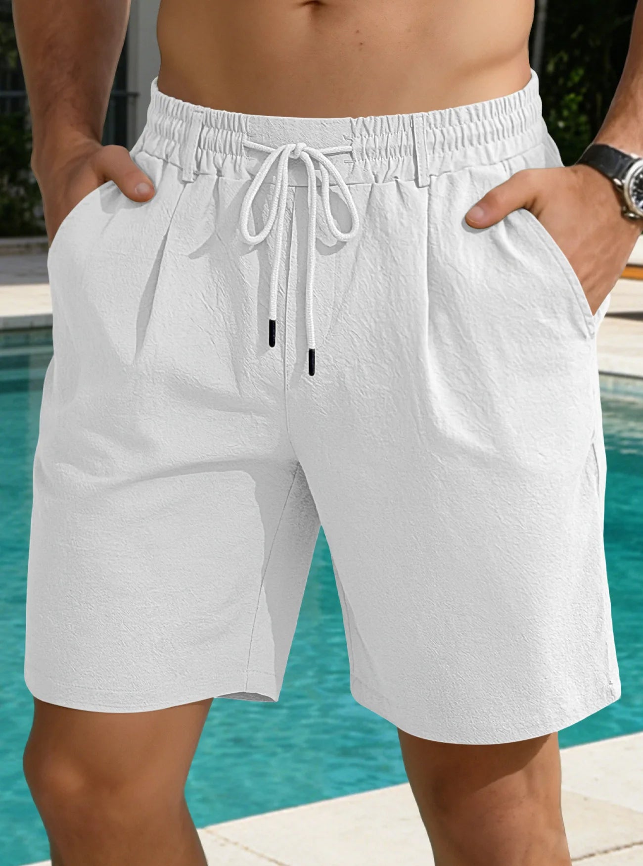 Person wearing white shorts with a drawstring by a pool