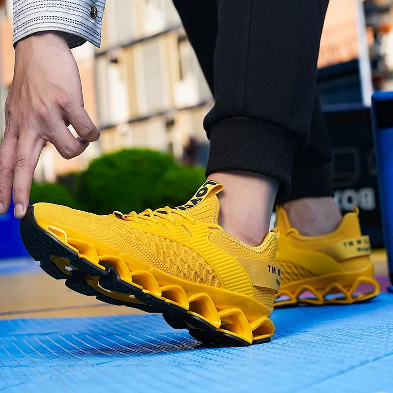 Yellow running shoes with unique sole design worn by a person on a blue surface.