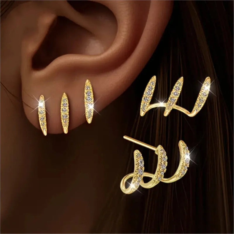 Gold earrings with intricate designs on a dark background