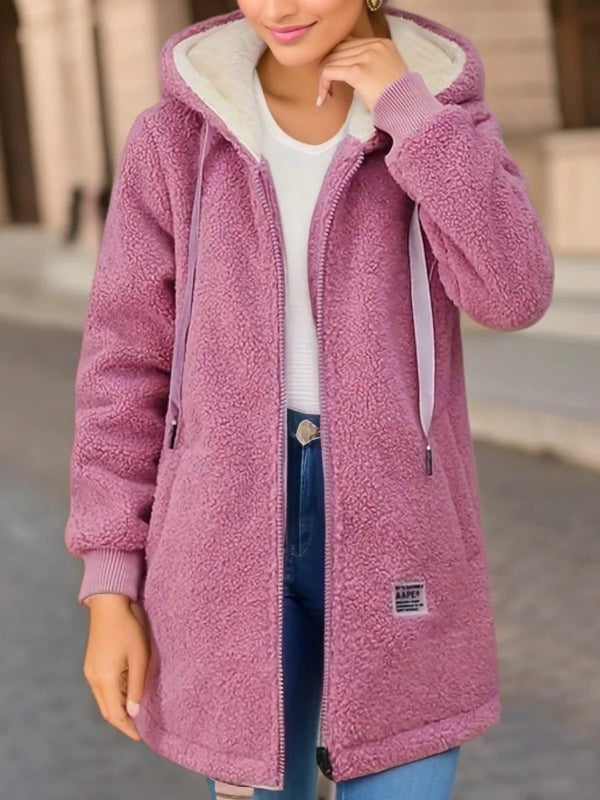 Person wearing a pink fleece jacket with a blurred background