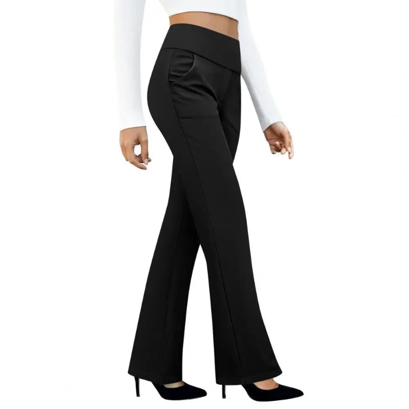 Black flared pants worn by a person on a white background