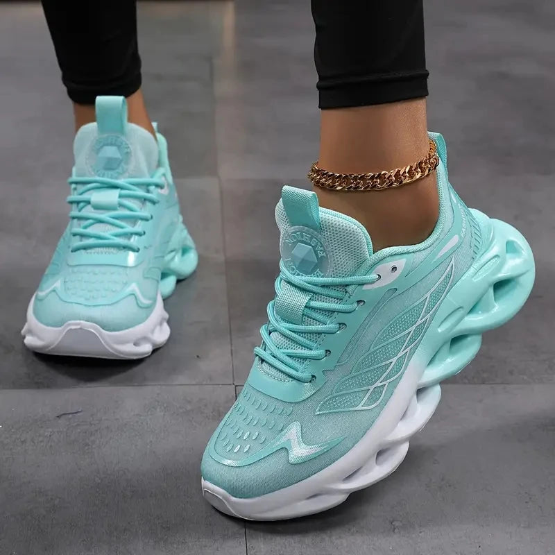 Turquoise sneakers worn with black pants on a gray floor.