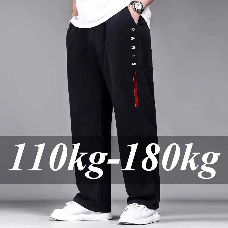 Person wearing black pants with a red stripe and 'PARIS' text, standing against a gray background.