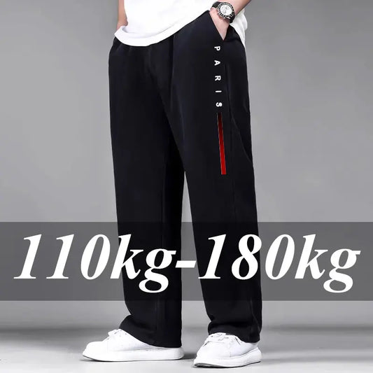 Person wearing black pants with a red stripe and 'PARIS' text, standing against a gray background.