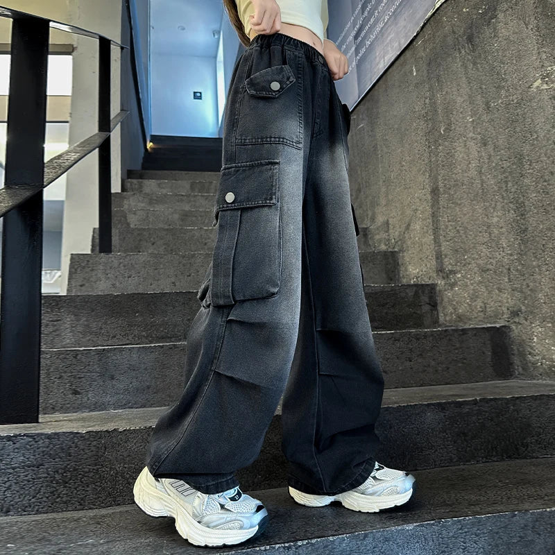Person wearing black wide-leg pants and white sneakers on a staircase.