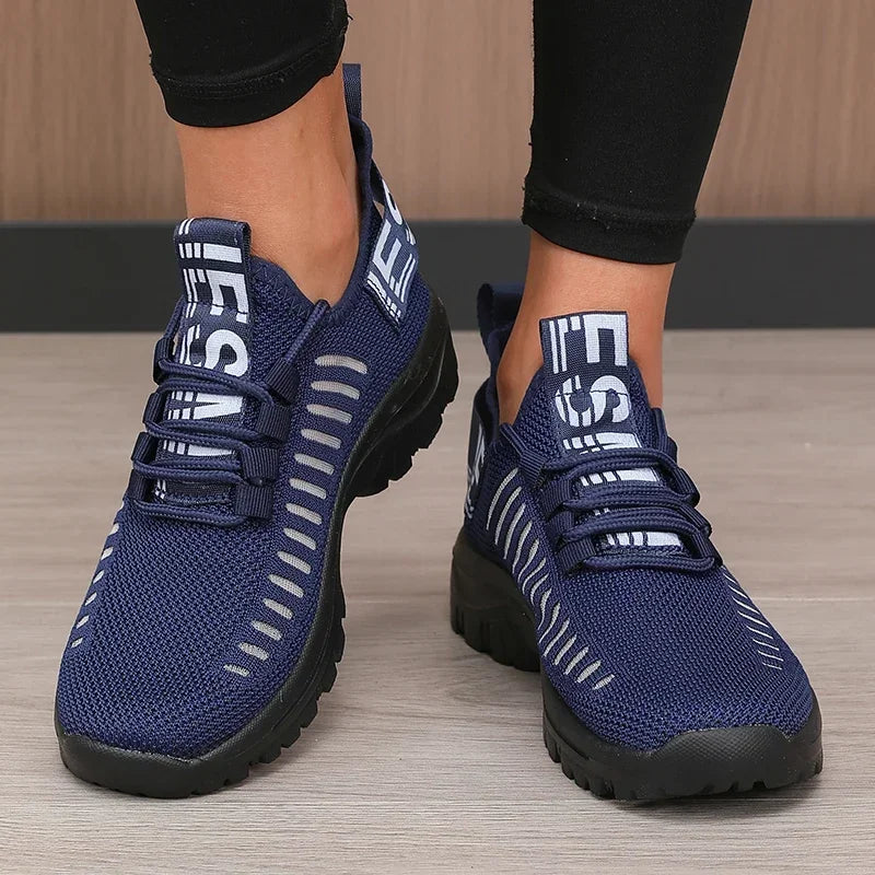 Blue athletic shoes with white accents on a wooden floor.