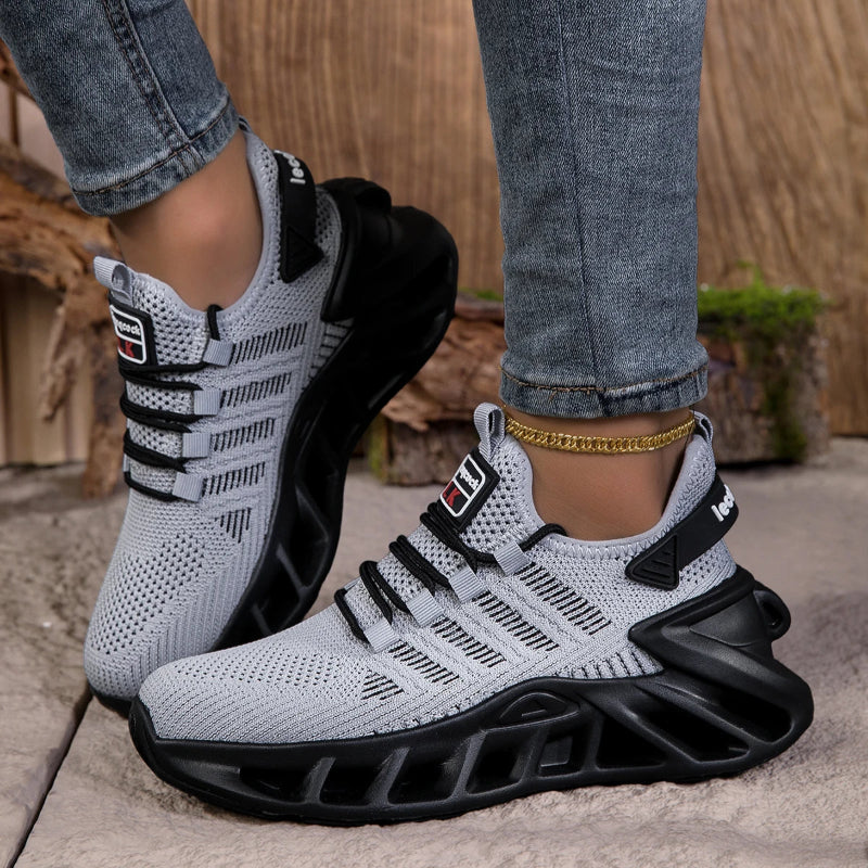 White and black athletic shoes worn with jeans on a neutral background