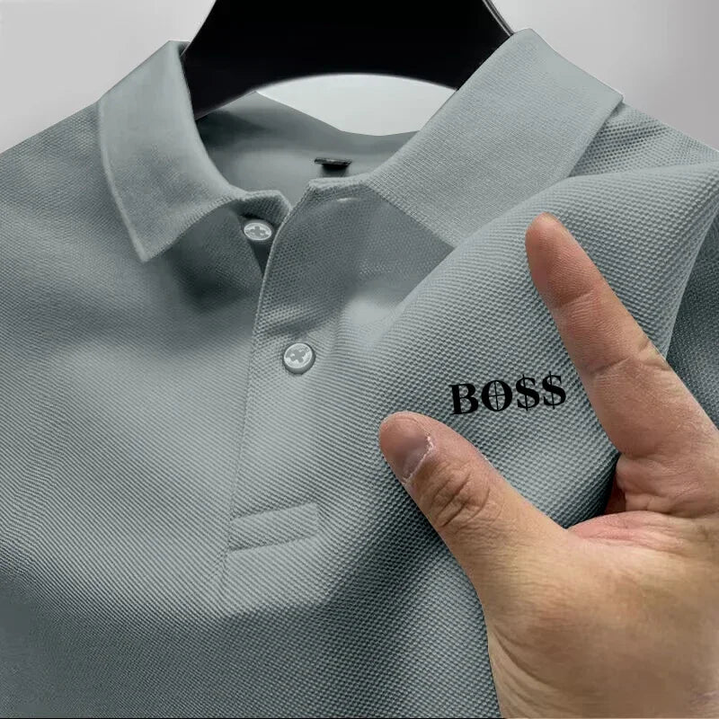 Gray polo shirt with 'BOSS' logo held by a hand on a light gray background
