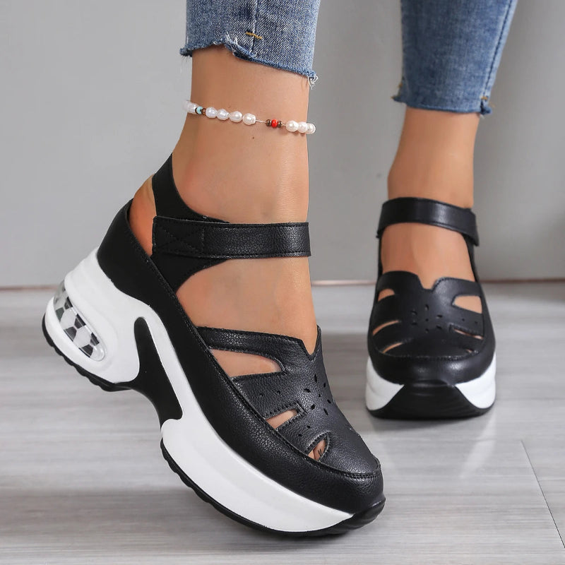 Black and white sandals worn with blue jeans on a neutral background