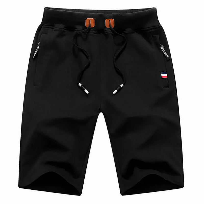 Black shorts with drawstring and small flag patch on a white background