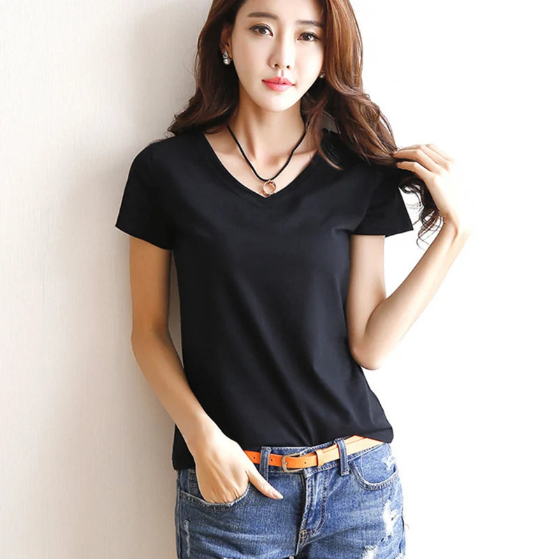 Woman wearing a black t-shirt and blue jeans against a plain background