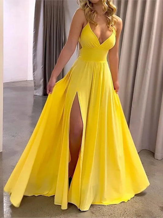 Yellow evening gown with a slit on a neutral background