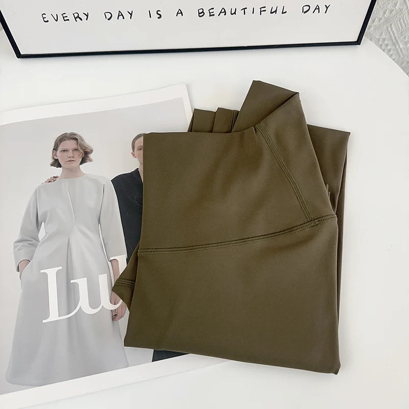 Folded olive green fabric with 'Lu' brand logo and motivational quote on a white surface