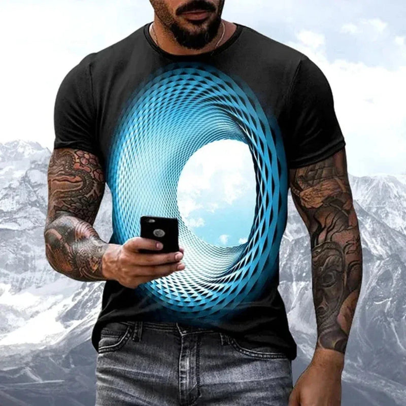Man wearing a black t-shirt with a blue circular design, holding a phone with a mountainous background.