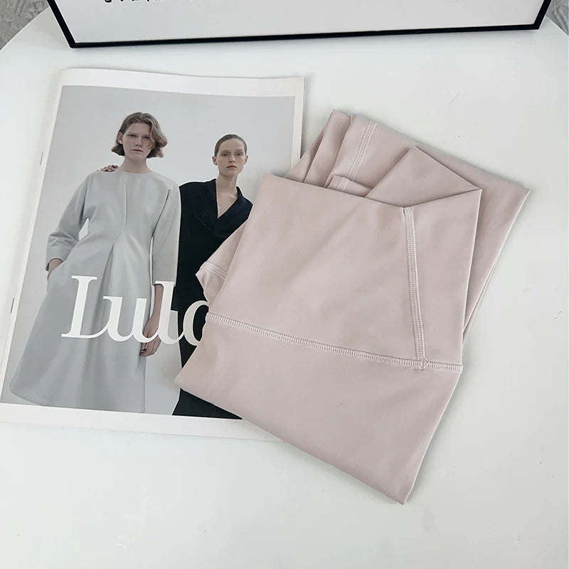 Folded pink fabric with a Lula magazine on a white surface