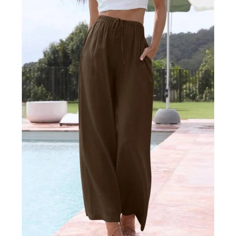 Person wearing brown wide-leg pants by a poolside