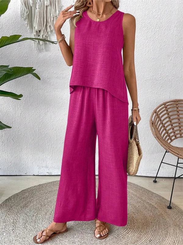 Woman wearing a magenta sleeveless top and wide-leg pants in a home setting.