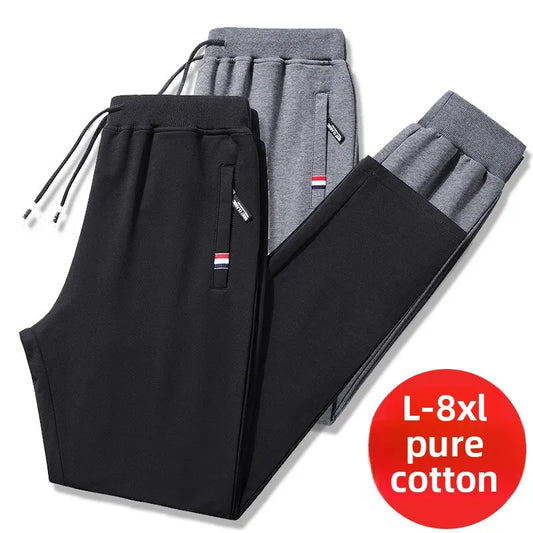 Black and gray sweatpants with a red label indicating size L-8xl and material on a white background.