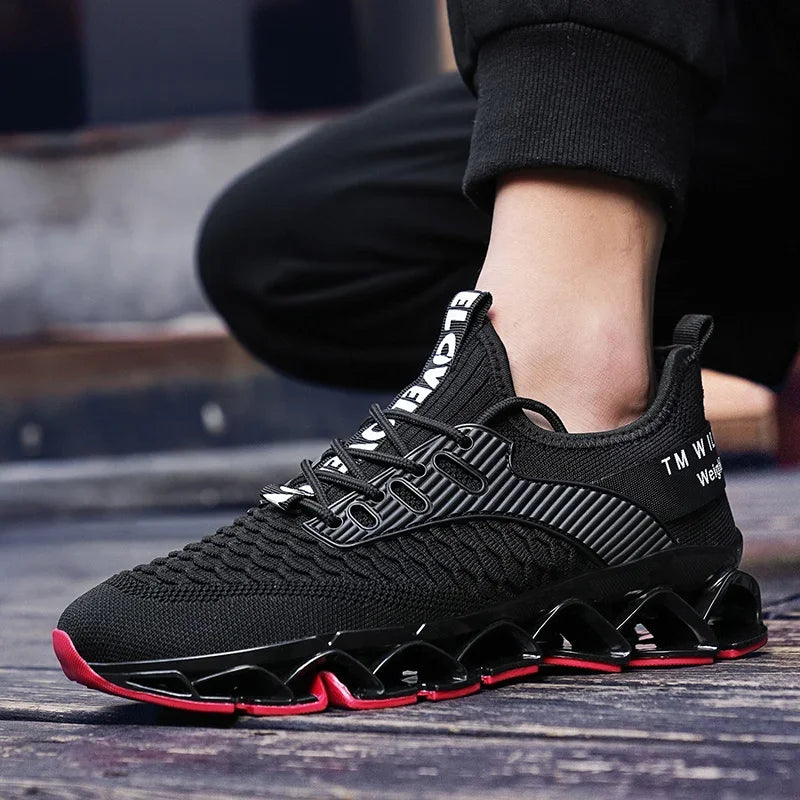 Black athletic shoe with red sole on a wooden floor