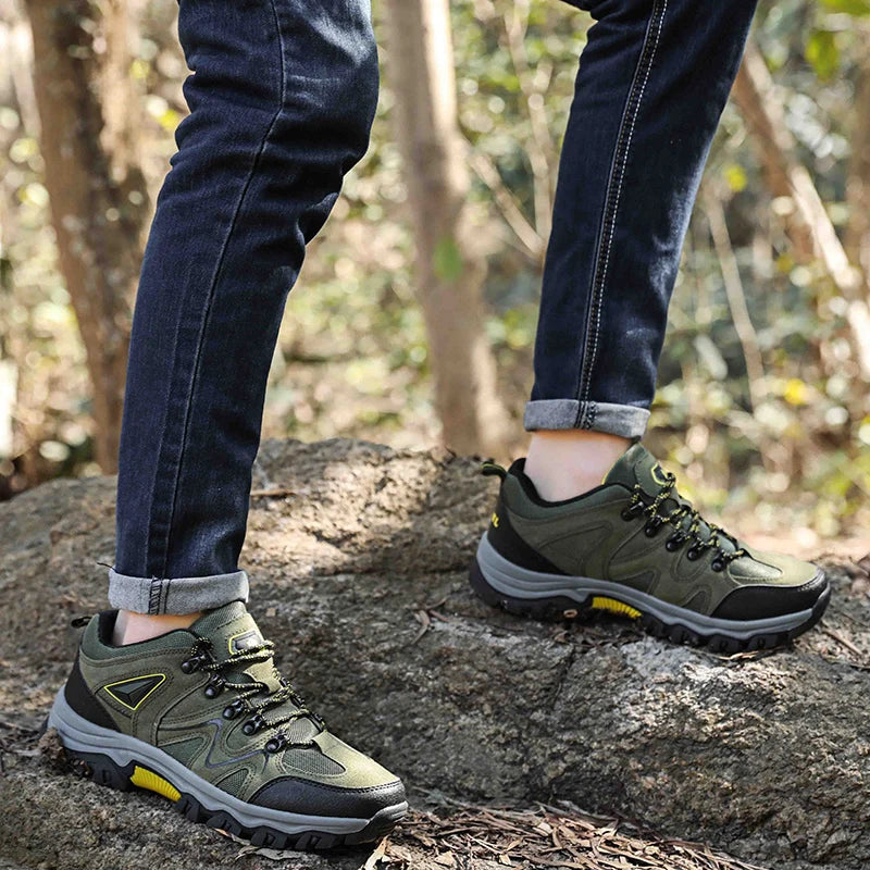 Person wearing green hiking shoes on a rocky surface with a natural background