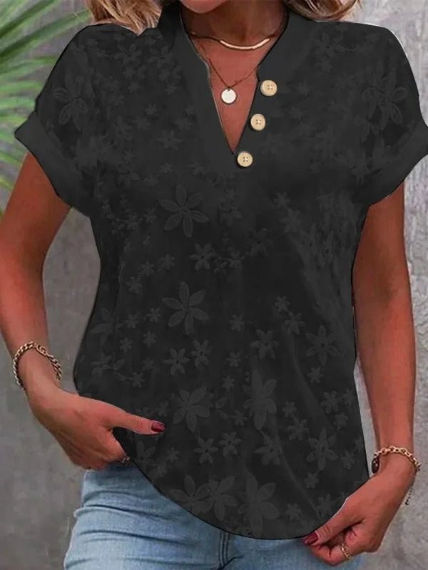 Black floral patterned shirt worn by a person with a neutral background