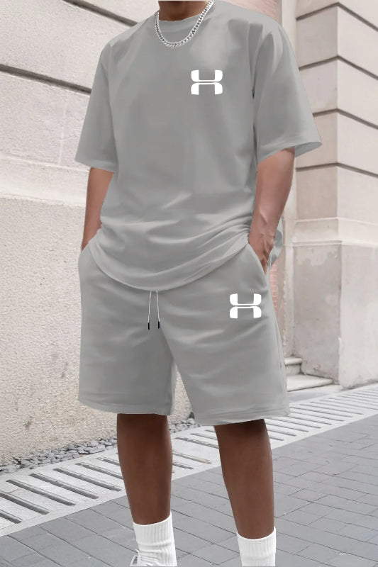 Person wearing a gray Under Armour outfit on a stone pavement.