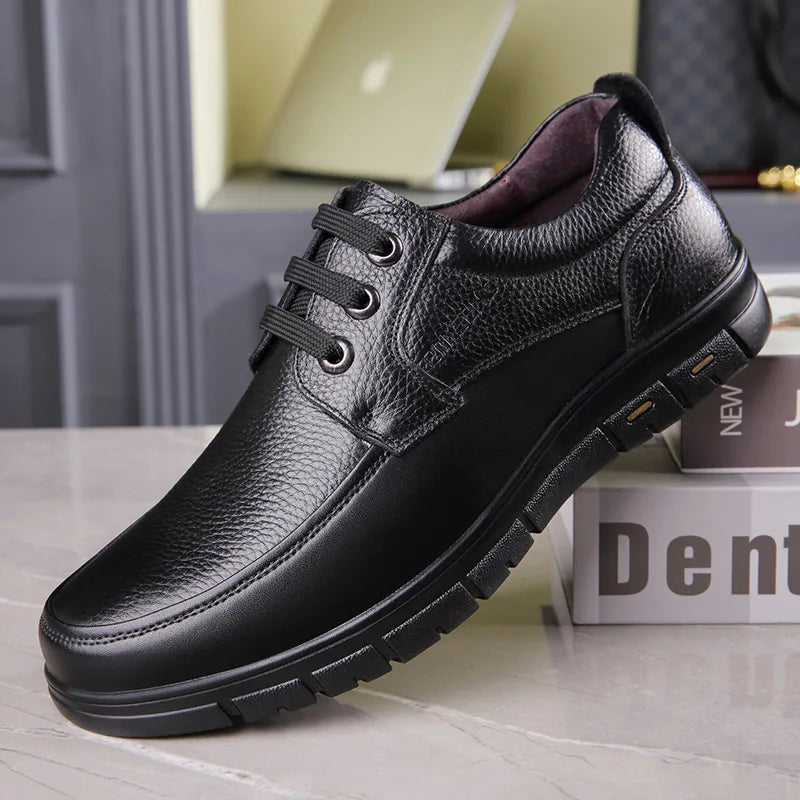 Black leather shoe on a gray surface with a blurred background