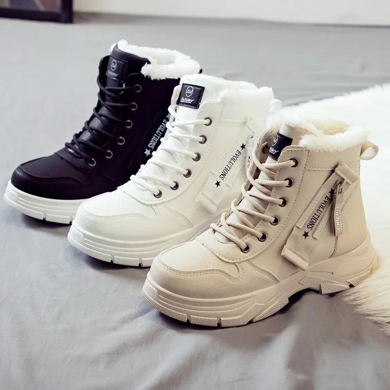 Three pairs of winter boots in black, white, and beige on a light gray surface.