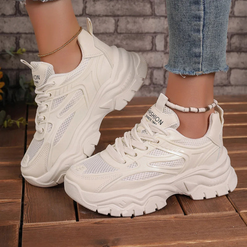White sneakers worn on a wooden floor with a brick wall background