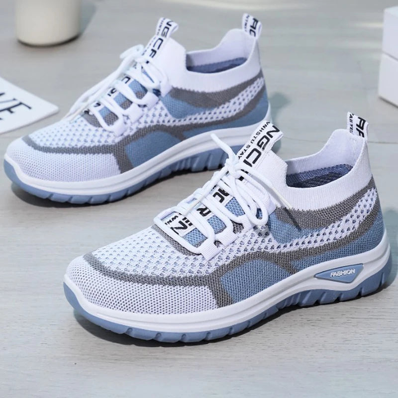 White and gray sneakers with blue accents on a light surface