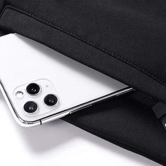 Close-up of a smartphone with a black case on a white surface
