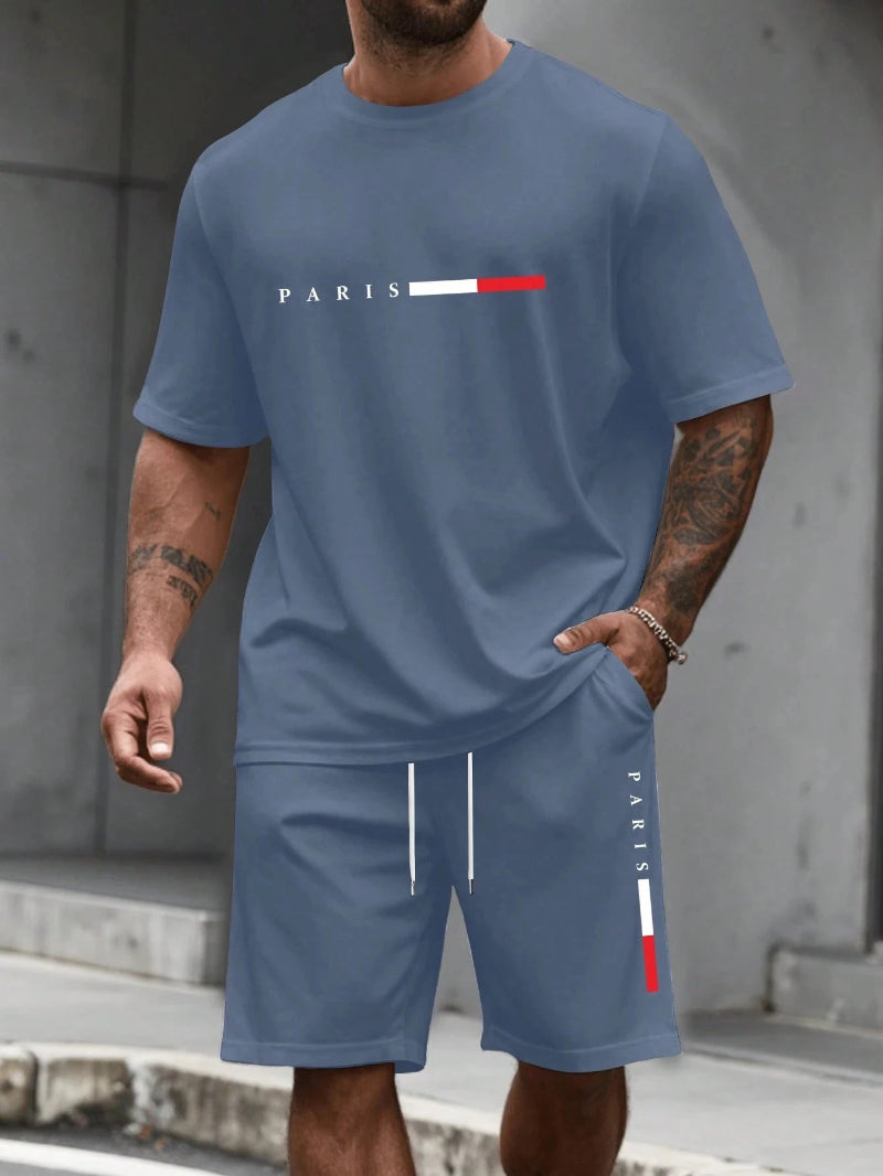 Person wearing a blue t-shirt and shorts set with 'PARIS' logo.