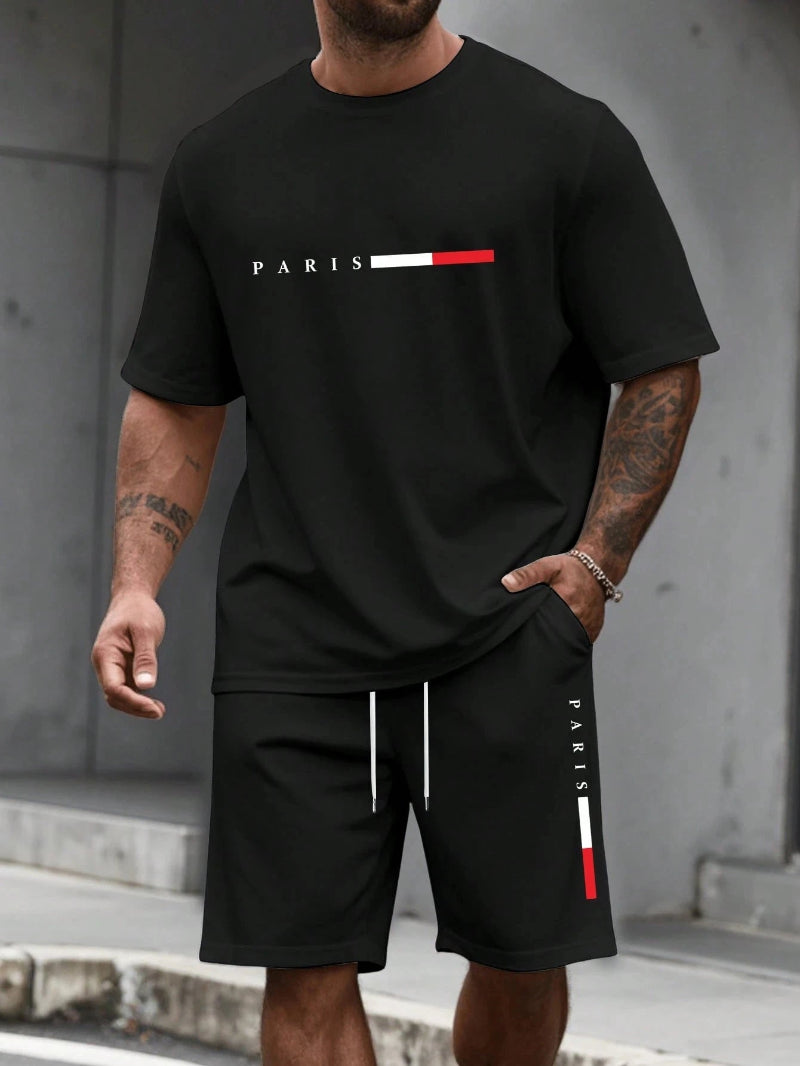 Person wearing a black t-shirt and shorts with 'PARIS' and a red and white stripe design.