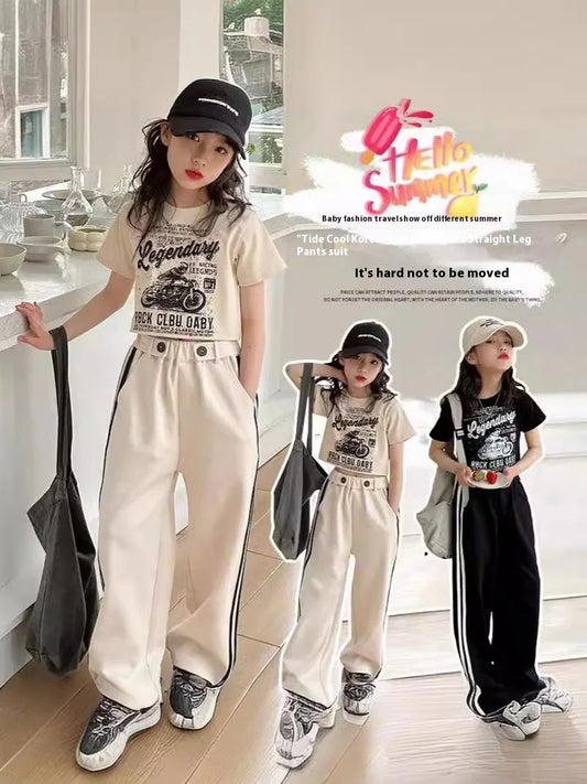 Three children wearing matching outfits with 'Legendary' t-shirts and white pants in a room.