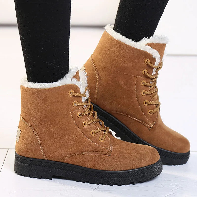 Brown winter boots with fur lining worn by a person on a light background