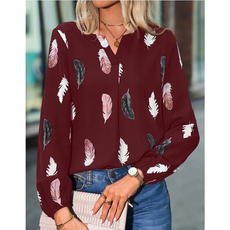 Woman wearing a burgundy blouse with feather pattern outdoors