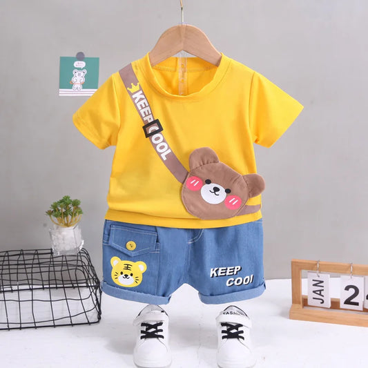 Children's outfit with yellow shirt, blue shorts, and bear design on a gray background